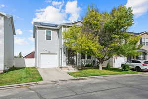 View of front of home featuring solar panels, concrete driveway, and an attached garage