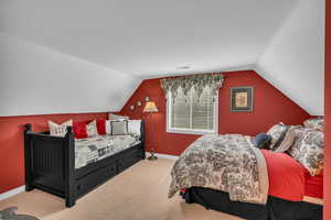 Bedroom with carpet flooring, vaulted ceiling, and baseboards