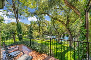 Deck featuring a water view and view of scattered trees