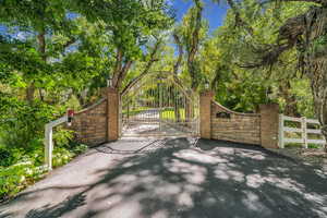 Gate with fence and view of wooded area