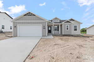 View of front facade featuring an attached garage, board and batten siding, driveway, central AC unit, and covered porch