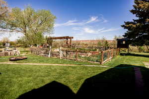 View of grassy yard with a vegetable garden and an outbuilding