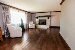 Living room featuring wood finished floors, crown molding, and baseboards