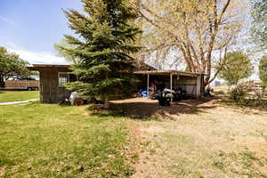 View of green lawn with storehouse/old rustic shop.