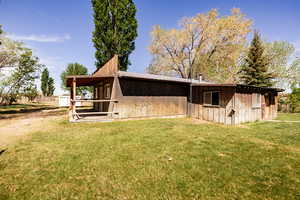 View of side of property with a yard and an outdoor structure