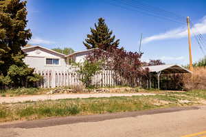View of side yard with a detached carport and fence
