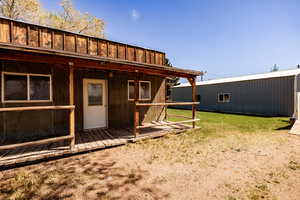 View of grassy yard with an old rustic shop/ storehouse.