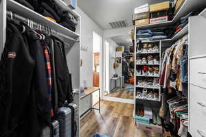 Walk in closet with wood finished floors