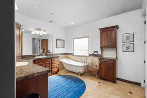 Bathroom with vanity, a soaking tub, a wainscoted wall, recessed lighting, and tile walls