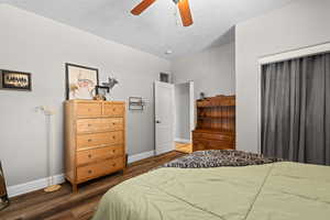 Bedroom featuring baseboards, wood finished floors, a textured ceiling, and ceiling fan