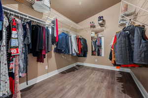 Spacious closet featuring wood finished floors and lofted ceiling