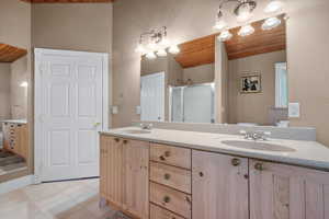 Full bath featuring wooden ceiling, a shower stall, double vanity, and tile patterned floors