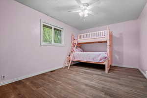 Bedroom with wood finished floors, baseboards, and ceiling fan