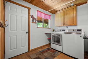 Laundry room featuring cabinet space, independent washer and dryer, wood ceiling, light wood-style flooring, and baseboards