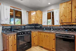 Kitchen with black appliances, a sink, light wood finished floors, healthy amount of natural light, and recessed lighting