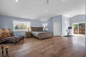 Bedroom with lofted ceiling, wood finished floors, access to outside, a ceiling fan, and baseboards