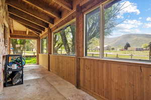 Unfurnished sunroom featuring a mountain view, plenty of natural light, and vaulted ceiling