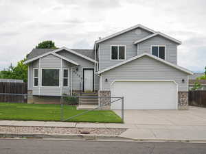 View of front of property featuring driveway, brick siding, and a garage