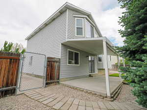 Back of house featuring a gate, a patio, and fence