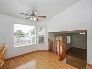 Unfurnished room featuring wood finished floors, a ceiling fan, and plenty of natural light