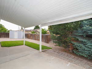 View of patio with a shed and an outdoor structure