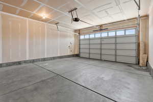 Garage with a garage door opener and baseboards