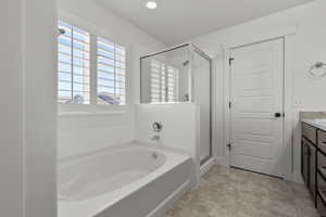 Full bath featuring a garden tub, a stall shower, vanity, and recessed lighting
