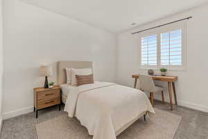 Carpeted bedroom featuring baseboards and vaulted ceiling