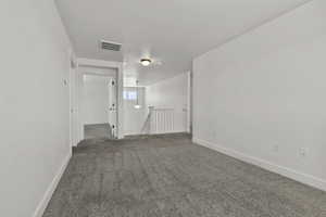 Carpeted spare room featuring baseboards