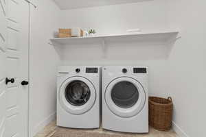 Washroom with independent washer and dryer and light tile patterned floors
