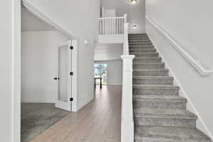 Stairway with wood finished floors and baseboards