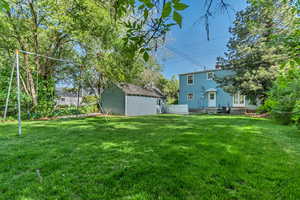 View of yard featuring an outdoor structure, entry steps, and a storage unit