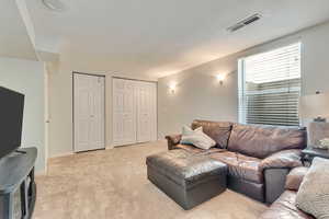 Living area with light carpet and baseboards