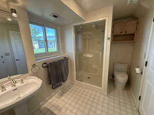 Full bathroom with tile patterned floors, a sink, a shower stall, toilet, and baseboards