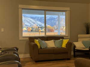 Living room featuring wood finished floors, baseboards, and a mountain view