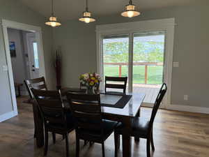 Dining area with wood finished floors, vaulted ceiling, and baseboards