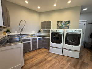 Clothes washing area featuring separate washer and dryer, light wood finished floors, and recessed lighting