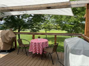 Deck featuring a lawn and a grill