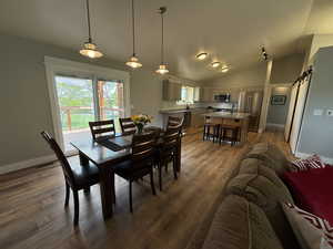 Dining space featuring lofted ceiling, wood finished floors, and baseboards