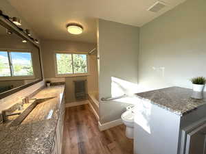 Full bath with wood finished floors, vanity, toilet, shower / tub combination, and decorative backsplash