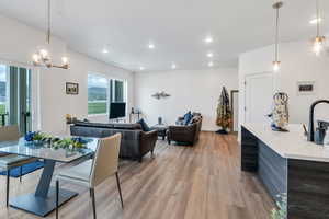 Dining room with light wood-style flooring, recessed lighting, a and a chandelier