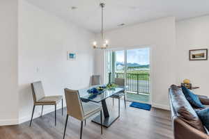 Dining room featuring a chandelier, wood finished floors, and a mountain view