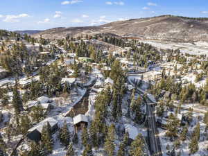 Snowy aerial view with a mountain view and a residential view
