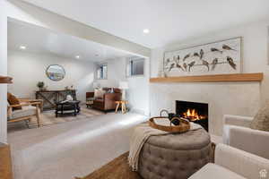 Living area with a fireplace, recessed lighting, and carpet