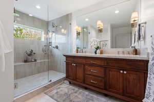 Bathroom featuring walk in shower, double vanity, and recessed lighting