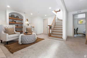Living area featuring carpet flooring, stairway, baseboards, and recessed lighting