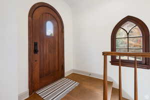 Entryway with wood finished floors, arched walkways, and baseboards