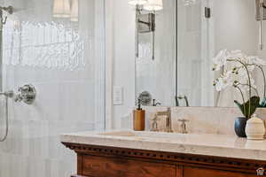 Bathroom featuring a tile shower and vanity