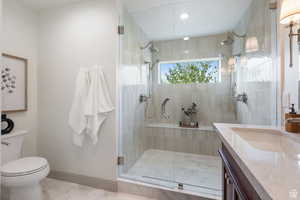 Bathroom featuring marble look tiles, a shower stall, toilet, vanity, and recessed lighting