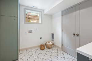Laundry room featuring electric dryer hookup, baseboards, washer hookup, and light tile patterned flooring